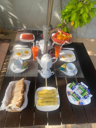una mesa de desayuno con huevos y comida. en Luaya Beach en Tangalle