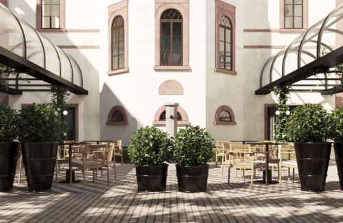 a courtyard with tables and chairs in front of a building at Hilton Heidelberg in Heidelberg