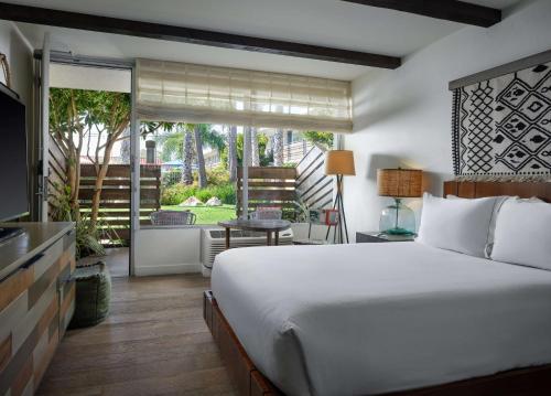 um quarto com uma cama grande e uma varanda em The Leta Santa Barbara Goleta, Tapestry Collection by Hilton em Santa Bárbara