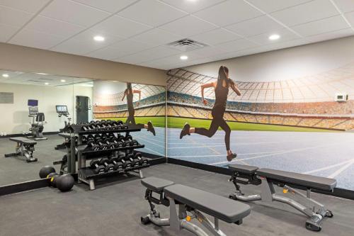 a gym with a mural of a woman running on a treadmill at Best Western Plus Fort Worth North in Fort Worth