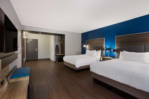 a hotel room with two beds and a flat screen tv at Tru By Hilton Traverse City in Traverse City