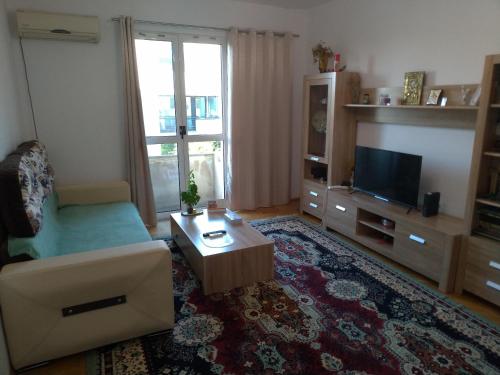 a living room with a couch and a tv at Apartament Promenada, 3 camere, max 6 persoane, locatie ideala, 10 min de mers pana la plaja in Constanţa