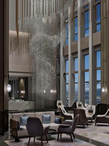 a lobby with couches and chairs in front of a building at Hilton Zhuji in Zhuji