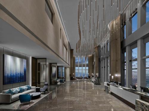 a lobby with couches and chairs in a building at Hilton Zhuji in Zhuji