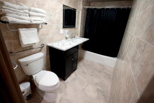 a bathroom with a toilet and a sink and a shower at Hotel Liberty Inn & Suites-JFK Airport- La Guardia Airport in Queens
