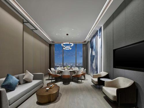 a living room with a couch and a table with chairs at Hilton Zhuji in Zhuji