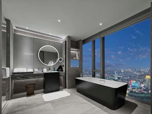 a bathroom with a tub and a view of a city at Hilton Zhuji in Zhuji