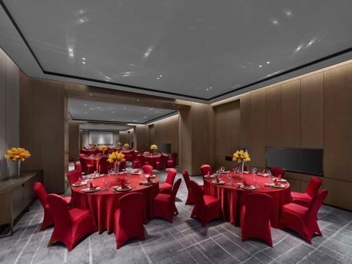 a conference room with red tables and red chairs at Hilton Zhuji in Zhuji