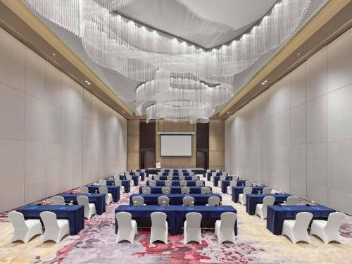 a large room with chairs and a projection screen at Hilton Zhuji in Zhuji