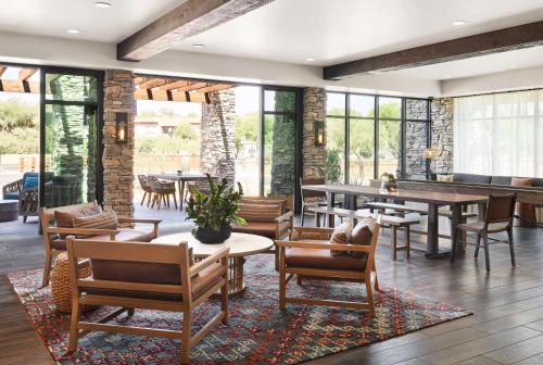 a dining room with tables and chairs and windows at The Eddy Hotel Tucson, Tapestry Collection By Hilton in Tucson