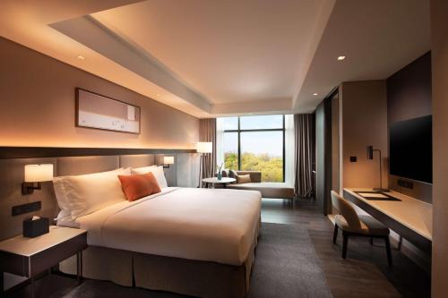 城南的住宿－DoubleTree By Hilton Seoul Pangyo，酒店客房设有一张大床和一张书桌。