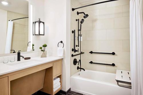 a bathroom with a tub and a sink and a shower at The Eddy Hotel Tucson, Tapestry Collection By Hilton in Tucson