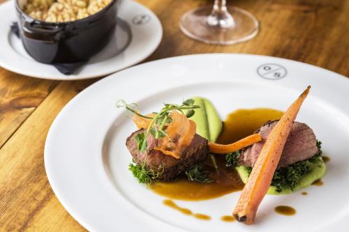a plate of food with meat and vegetables on a table at The Old Stocks Inn in Stow on the Wold