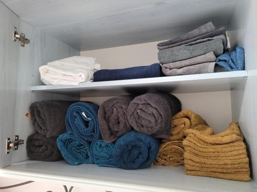 un placard rempli de nombreuses serviettes et couvertures dans l'établissement Le Bluey, à Chabris