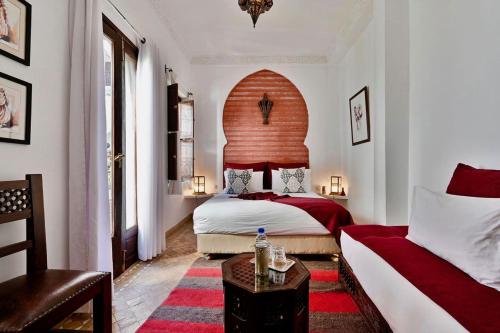 una camera con letto, tavolo e divano di DAR ESSHRA a Marrakech