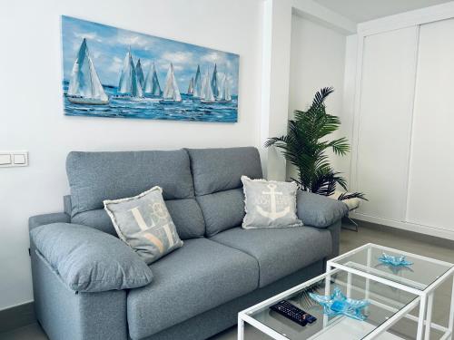 a living room with a couch and sailboats in the water at Mare Apartments Marbella in Marbella