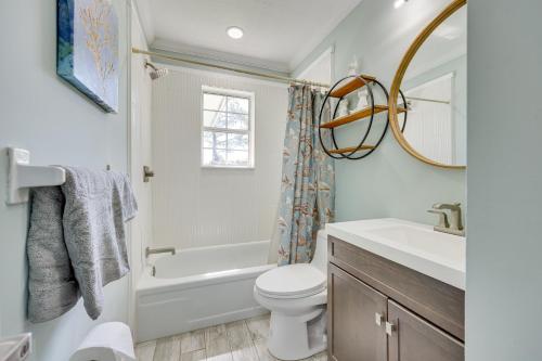 a bathroom with a toilet and a sink and a mirror at Modern Coastal Home with Pool Mins to Beach and Mayo! in Jacksonville Beach