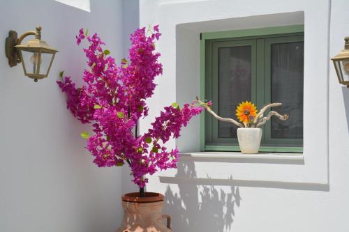 a vase with purple flowers on a window sill at The Priest's Traditional House Kalithies in Kalithies