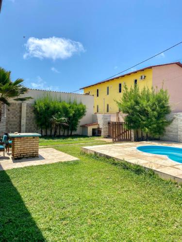 a yard with a swimming pool and a building at Casa Rústica em Morro Branco - na quadra da praia in #N/A
