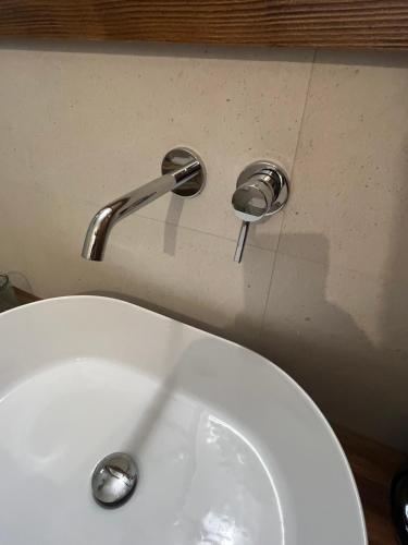 a bathroom sink with a faucet on the wall at The Priest's Traditional House Kalithies in Kalithies