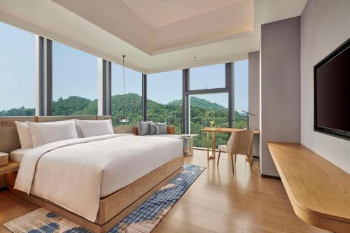 - une chambre avec un grand lit et une télévision à écran plat dans l'établissement DoubleTree by Hilton Guangzhou Zengcheng, à Canton