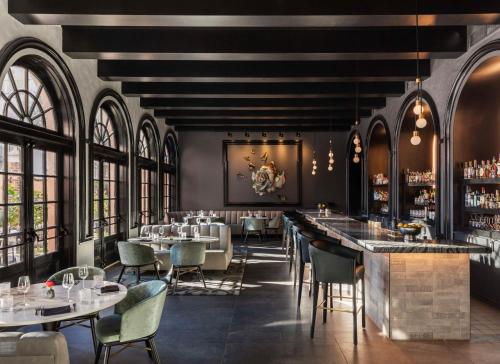 a restaurant with tables and chairs and a bar at Mills House Charleston, Curio Collection by Hilton in Charleston