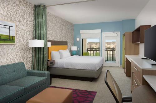 Flower MoundにあるHome2 Suites By Hilton Flower Mound Dallasのベッドとソファ付きのホテルルーム