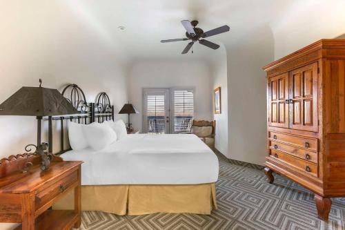 Hilton Vacation Club Rancho Manana في كيف كريك: غرفة نوم مع سرير أبيض كبير وخزانة