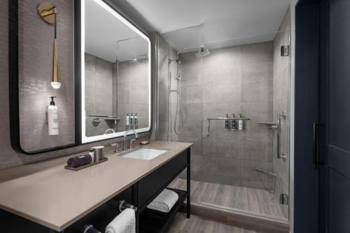 a bathroom with a sink and a shower at Hotel Fraye Nashville, Curio Collection By Hilton in Nashville