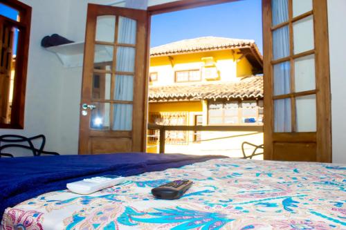 a bedroom with a bed with a remote control on it at Suíte na vila de Praia do Forte in Praia do Forte
