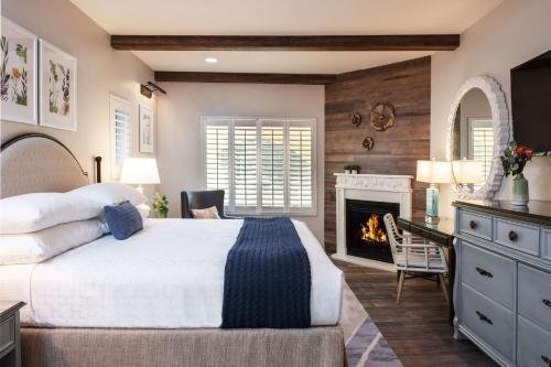 希尔兹堡The Lodge at Healdsburg, Tapestry Collection by Hilton的带一张大床和一个壁炉的卧室