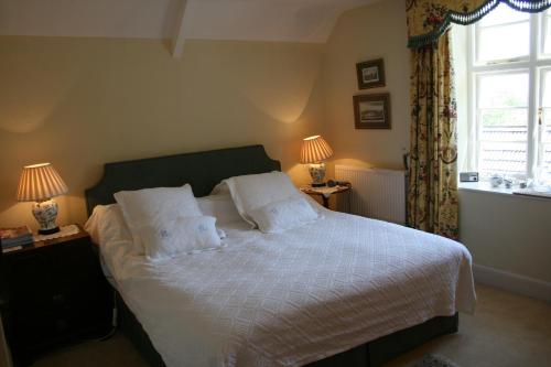 - une chambre avec un lit, deux lampes et une fenêtre dans l'établissement Helmdon House Bed and Breakfast, à Helmdon