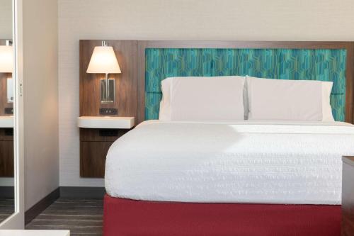 a bedroom with a large white bed with a red blanket at Hampton Inn & Suites Santa Rosa Sonoma Wine Country in Santa Rosa
