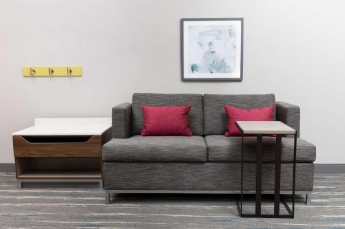 a living room with a gray couch and pink pillows at Hampton Inn & Suites Santa Rosa Sonoma Wine Country in Santa Rosa