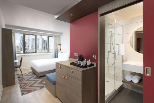ein Hotelzimmer mit einem Bett und einem Bad in der Unterkunft Hampton By Hilton London City in London