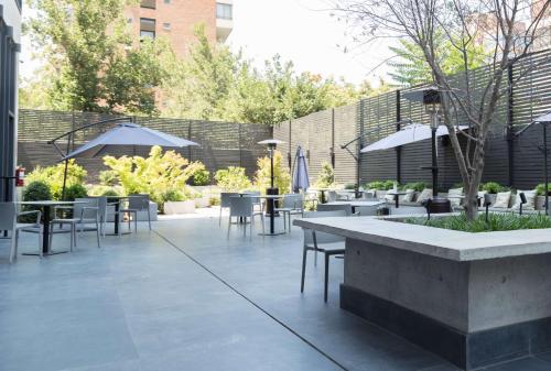a patio with tables and chairs in a courtyard at Ola Santiago Providencia, Tapestry Collection by Hilton in Santiago
