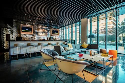 a lobby with a couch and chairs and a bar at Ola Santiago Providencia, Tapestry Collection by Hilton in Santiago