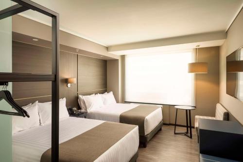 um quarto de hotel com duas camas e uma janela em Ola Santiago Providencia, Tapestry Collection by Hilton em Santiago