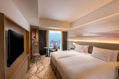 um quarto de hotel com duas camas e uma televisão de ecrã plano em DoubleTree by Hilton Toyama em Toyama
