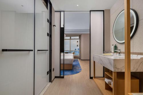 uma casa de banho com um lavatório e um espelho em Hilton Garden Inn Shanghai Lujiazui em Xangai