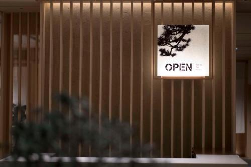 een bord dat zegt open op een muur bij DoubleTree by Hilton Kyoto Higashiyama in Kyoto