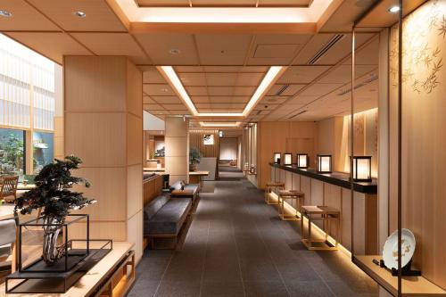 a lobby of a building with benches and tables at DoubleTree by Hilton Kyoto Higashiyama in Kyoto