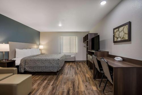 a hotel room with a bed and a desk at WoodSpring Suites Milwaukee - Menomonee Falls in Milwaukee