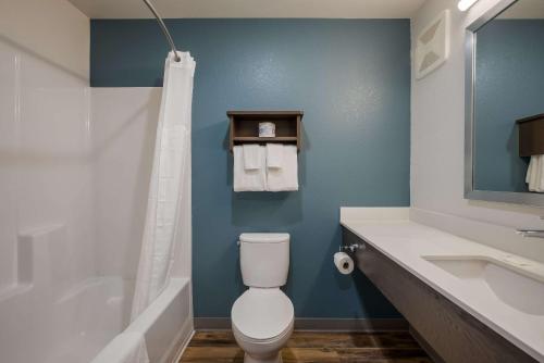a bathroom with a toilet and a sink and a shower at WoodSpring Suites Milwaukee - Menomonee Falls in Milwaukee