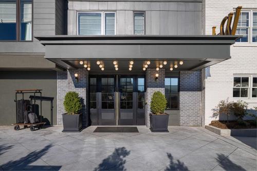 a entrance to a building with awning and potted plants at Wylie Hotel Atlanta, Tapestry Collection by Hilton in Atlanta