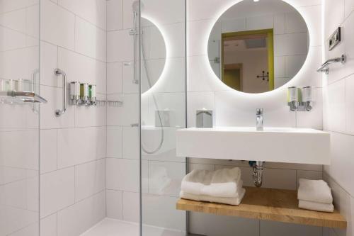 a bathroom with a shower and a sink and a mirror at Hampton By Hilton Cerkezkoy in Tekirdag
