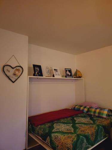 a bedroom with a bed and a shelf with pictures at Dolly Apartment Airport in Velika Gorica