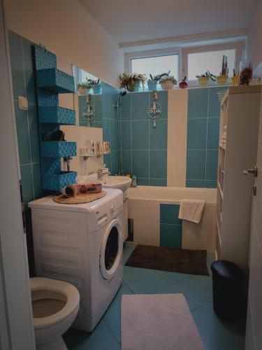 a bathroom with a toilet and a washing machine at Dolly Apartment Airport in Velika Gorica
