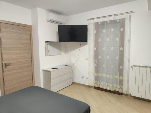 拉蒂納的住宿－Villa A&M 2，一间卧室配有一张床、梳妆台和电视。