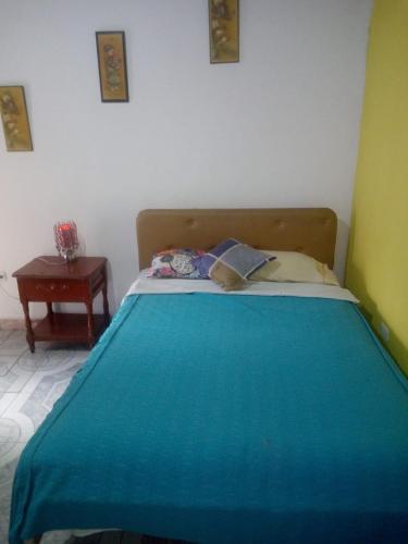 a bedroom with a blue bed with a table at Hotel Tanta Wasi-Panecillo in Quito